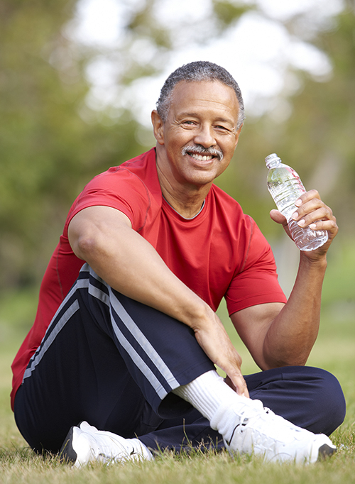 photo of a senior man relaxing after exercise and drinking water